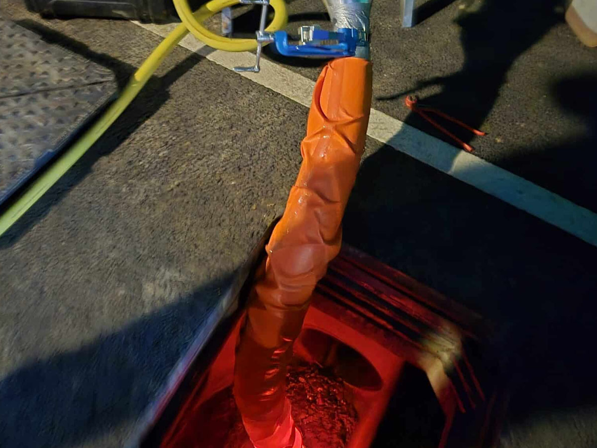 Feeding a resin-impregnated structural liner into a commercial drain.